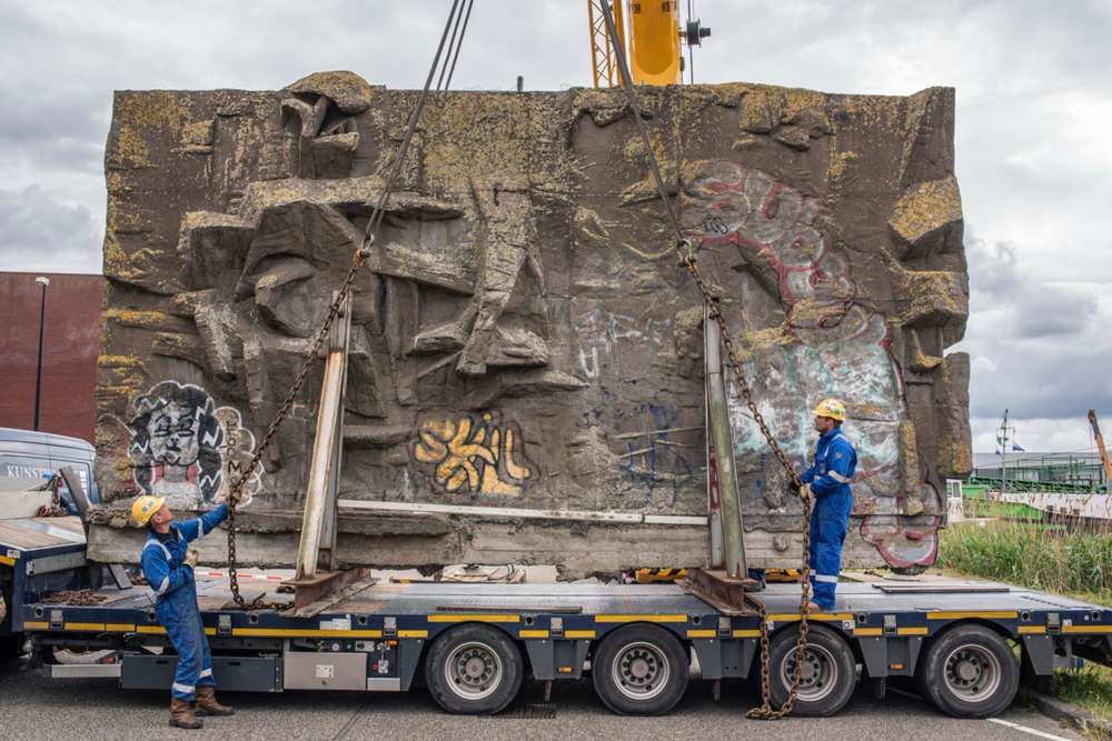 Het betonreli&euml;f van Pierre van Soest wordt in 2019 met een kraan op een dieplader gezet voor de reis naar de Binckhorst