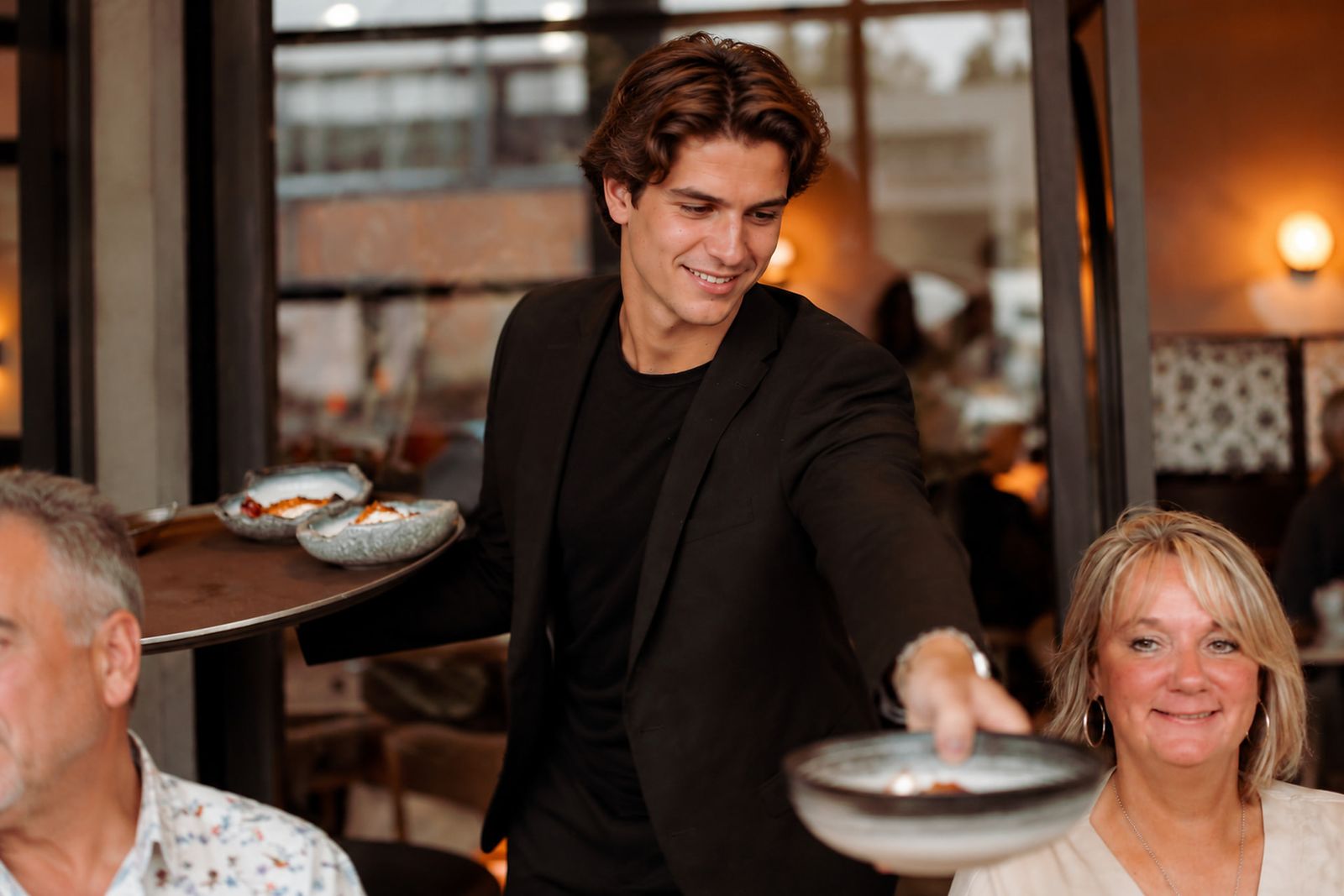 Collega van de bediening serveert aan tafel